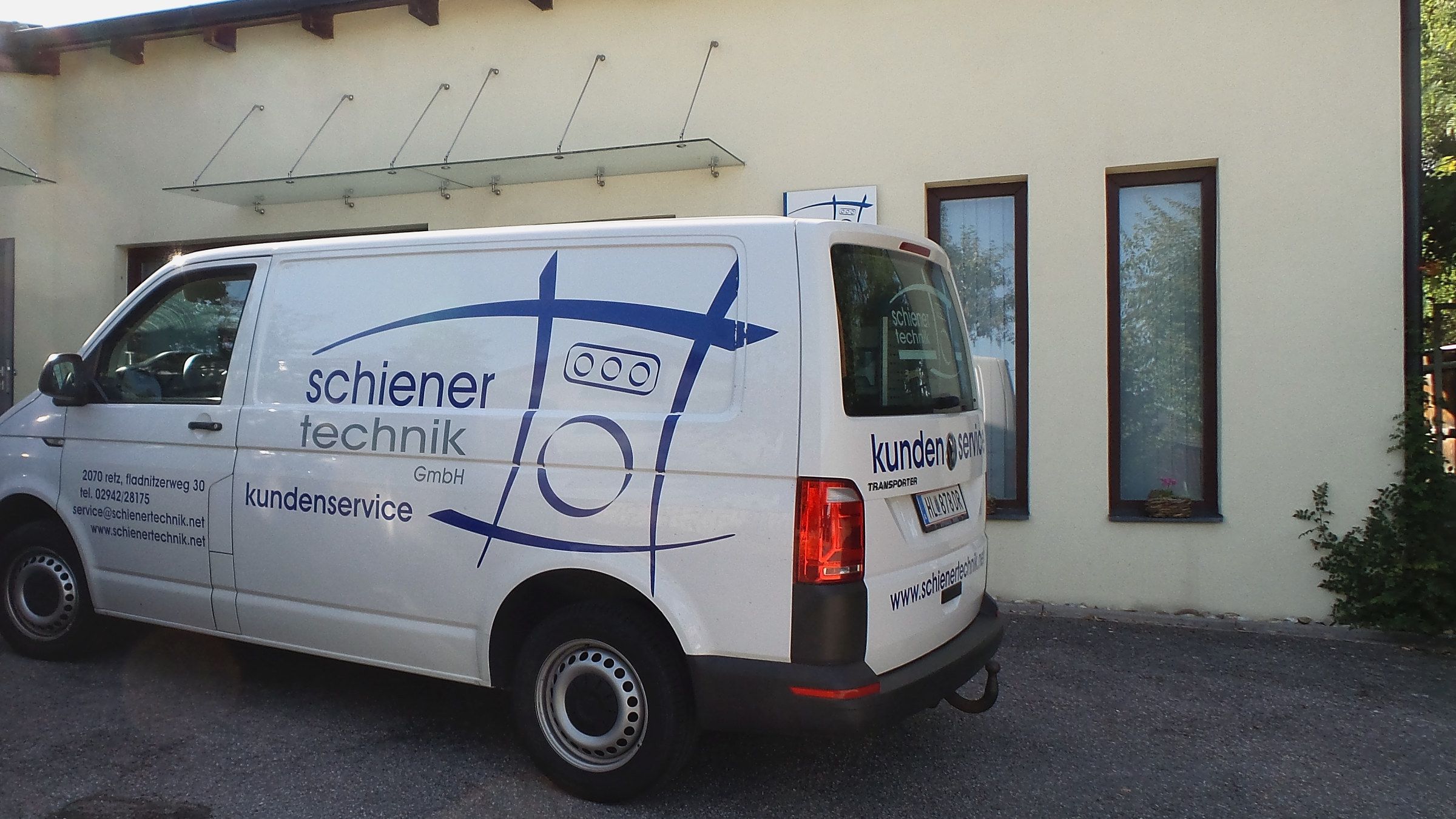 Weißes Servicefahrzeug mit Schiener-Technik-Beschriftung vor dem Firmengebäude in Retz